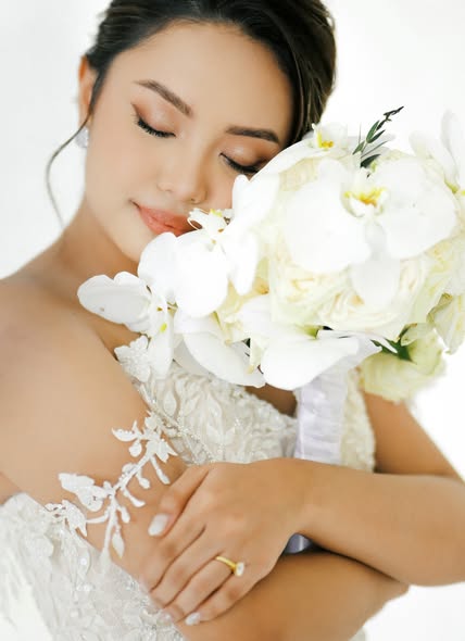 Bride holding white flowers in a quiet portrait